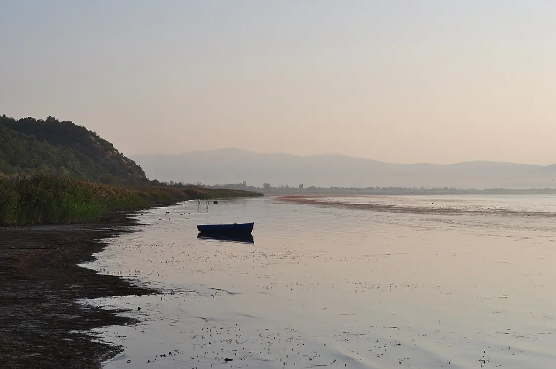 A boat on the shore of Lake Prespa at sunrise in Oteševo